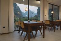 兴义Fanzhu Hotel的一间有桌椅和大窗户的餐厅