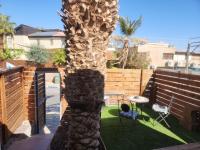 eine Palme in einem Hinterhof mit einem Tisch und Stühlen in der Unterkunft Shalom&#39;s place in Eilat