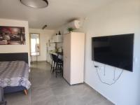 ein Schlafzimmer mit einem Bett und einem Flachbildfernseher an der Wand in der Unterkunft Shalom&#39;s place in Eilat