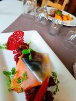 un plato blanco con un trozo de pescado en una mesa en Auberge des Montauds - Hôtel & Restaurant, en Villard-de-Lans