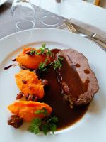 Un plato de comida con carne y verduras en una mesa. en Auberge des Montauds - Hôtel & Restaurant, en Villard-de-Lans