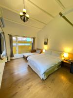 a bedroom with two beds and a large window at Alishan Tea Garden B&amp;B in Fenqihu
