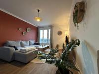 ein Wohnzimmer mit einem Sofa und einer Pflanze in der Unterkunft Appartement NEUF et cosy à Blois in Blois