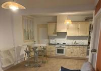 eine Küche mit weißen Schränken, einem Tisch und Stühlen in der Unterkunft Appartement NEUF et cosy à Blois in Blois
