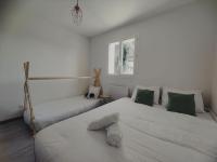 a white bedroom with two beds and a window at New ! Pura Vida - Villa familiale récente à Châteauneuf de Grasse in Châteauneuf