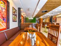 une salle à manger avec des tables et des bancs en bois dans l'établissement Mangal Residency Rooftop Pool, à Udaipur