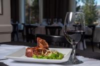 einen Teller mit Essen und ein Glas Wein auf dem Tisch in der Unterkunft Amérian Aluminé in Aluminé