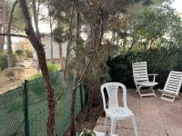 a group of white chairs sitting next to a tree at Appartement Agde, 2 pièces, 5 personnes - FR-1-749-42 in Cap d&#39;Agde