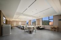 Un comedor con mesas y sillas y ventanas. en Atour Hotel Ningbo Ninghai, en Ninghai