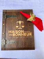 Una placa de madera con una medalla y una cinta roja. en Maison du Bonheur, en Dakar