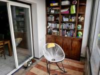 a white chair in a room with a book shelf at Appart T3 Spacieux + Terrasse in Montpellier