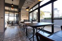 a dining room with tables and chairs and windows at 1999 B&amp;B in Hualien City