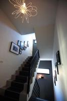 a staircase with a chandelier and pictures on the wall at 1999 B&amp;B in Hualien City