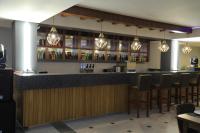 a bar in a restaurant with chairs and lights at HOBIZ Hotel in Navoi