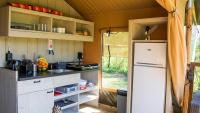 a kitchen with white cabinets and a refrigerator at Glamping Bretagne in Quimper