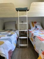 a bedroom with two beds and a bunk bed at MH VAL&amp;YVAN plage, piscine pointe de Trévignon et concarneau in Trégunc