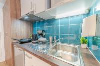 a kitchen with a sink and a blue tiled wall at Break &amp; Home Paris Italie Porte de Choisy in Ivry-sur-Seine