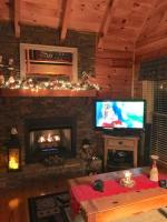 ein Wohnzimmer mit Kamin und Fernseher in der Unterkunft Solid Ground Lodge with Yard! in Pigeon Forge