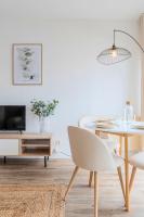 a white living room with a table and a chair at Europe&#47;Flandres stations apartment with balcony! in Lille