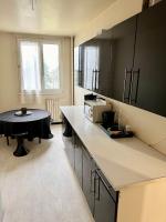 a kitchen with a counter and a table with a microwave at Appartement à 5mn du centre ville Compiegne in Compiègne