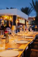 un lungo tavolo in legno con piatti e bicchieri da vino di Harbor Hotel & Casino Curacao a Willemstad