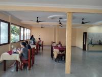 a group of people sitting at tables in a restaurant at The Lake Paradise Boutique Resort in Alleppey
