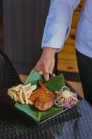 a person holding a plate of food with french fries at The Regalia Resort in Mandrem