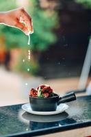 a person pouring sauce into a bowl of food at The Regalia Resort in Mandrem
