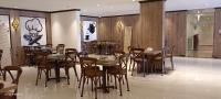 a restaurant with wooden tables and chairs in a room at فندق بلفيو بارك رويال Bellevue Park Royal Hotel in Taif