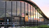 a large glass building with a train reflected in it at Marcq-en-Baroeul - beautiful fully equipped ! 2p in Marcq-en-Baroeul