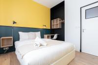 a bedroom with a bed and a yellow wall at Marcq-en-Baroeul - beautiful fully equipped ! 2p in Marcq-en-Baroeul