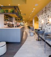 a restaurant with a bar and stools at The Wesley Euston in London
