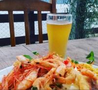 een bord garnalen en een glas bier bij Chalés do Atlântico Sc in Itapoa