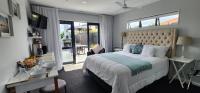 Un dormitorio con una cama grande y un balcón. en Sunkist B &amp; B, en Papamoa