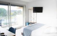 a hotel room with a bed and a large window at Tiercé Hotel in Cagnes-sur-Mer