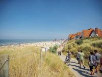 a group of people riding bikes on a path near the beach at Blomme 0202 exclusive apartment with sea view in De Haan