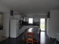 a kitchen with a table and a white refrigerator at La casa en el campo A 20 minutes de Zoo Beauval &amp; 8 minutes de la flamme olympique à Valençay in Vicq-sur-Nahon