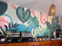 a kitchen with a wall with a tropical mural at Arcadia Suites - Kampala in Kampala