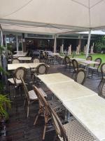 een buitenterras met tafels, stoelen en parasols bij ocean view, on the beach. in Le Gosier