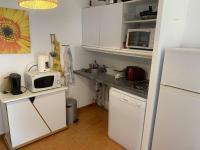 eine kleine Küche mit weißen Schränken und einer Mikrowelle in der Unterkunft Appartement Sainte-Maxime, 2 pièces, 4 personnes - FR-1-768-68 in Sainte-Maxime