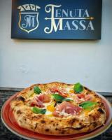 una pizza sentada en un plato en una mesa en Sky and Green Luxury Apartament, en Boscoreale