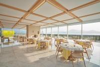 Un restaurante con mesas y sillas y grandes ventanales. en Simose Art Garden Villa, en Kuba