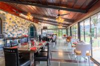 een eetkamer met tafels en stoelen en ramen bij Residency Lake Resort & Spa in Mulshi