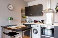 a kitchen with a washer and dryer and a clock at Vieux Lille appartement 1 chambre in Lille