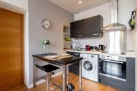 a kitchen with a table and a dishwasher at Vieux Lille appartement 1 chambre in Lille