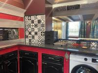 a kitchen with black cabinets and a washer and dryer at La Domus Lemaitre 1, plain-pied, Wifi , TV, parking, jardin 