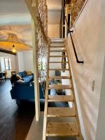 a wooden staircase in a living room with a blue couch at Le Planzollais in Planzolles