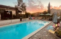 a swimming pool with a sunset in the background at Le Planzollais in Planzolles