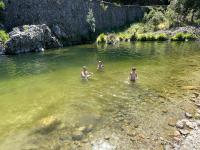 three people swimming in a body of water at Le Planzollais in Planzolles