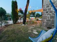 a hammock in a yard with a table and chairs at Le Planzollais in Planzolles